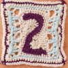 Purple, white, and light blue crochet square showing the number 2 in the centre