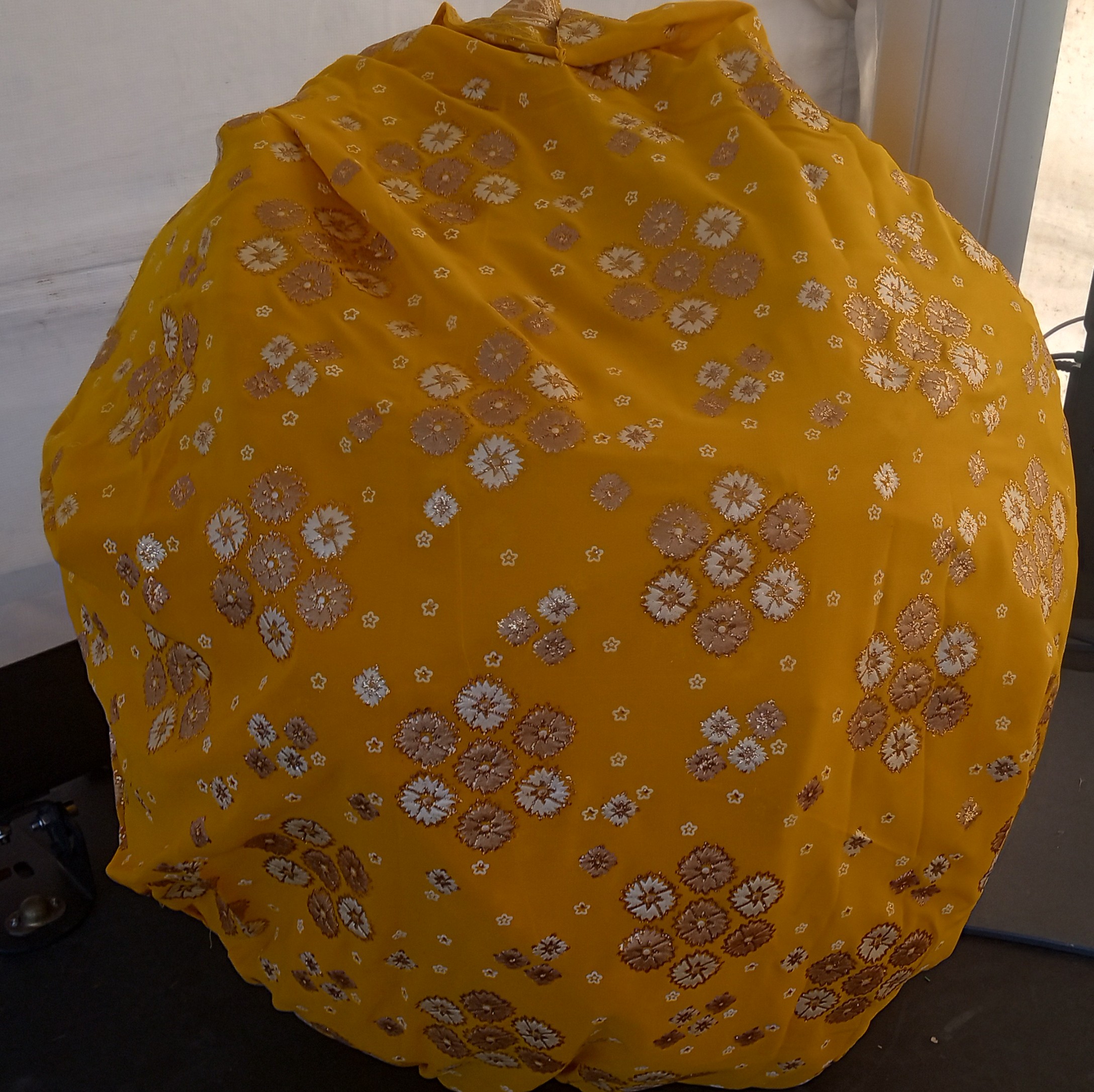 A large yellow sun with glittery white and silver flower patterns